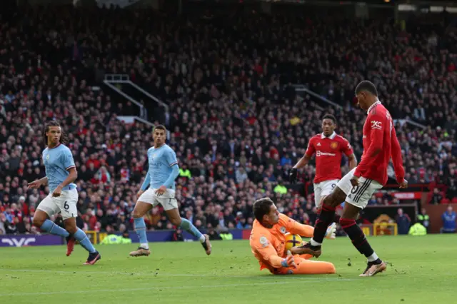 Man City keeper Ederson smothers a shot from Man Utd forward Marcus Rashford.