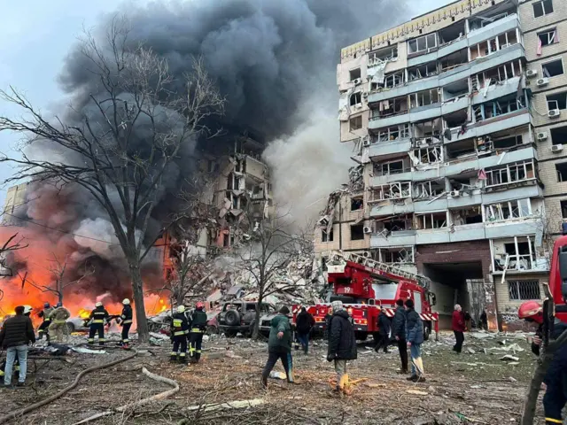 Emergency workers at the scene of a Russian missile strike on a residential building in the city of Dnipro