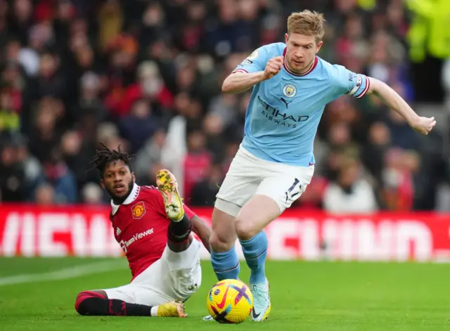 Man City's Kevin de Bruyne sprints away from a sliding challenge.