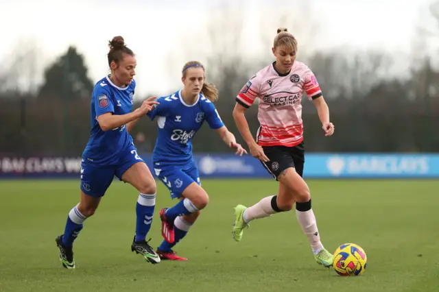 Reading's Gemma Evans is put under pressure by Everton defenders.