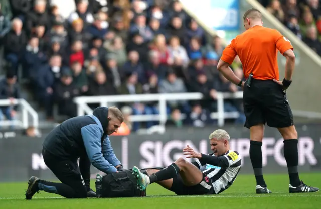 Newcastle physios tend to the injured Bruno Guimaraes.