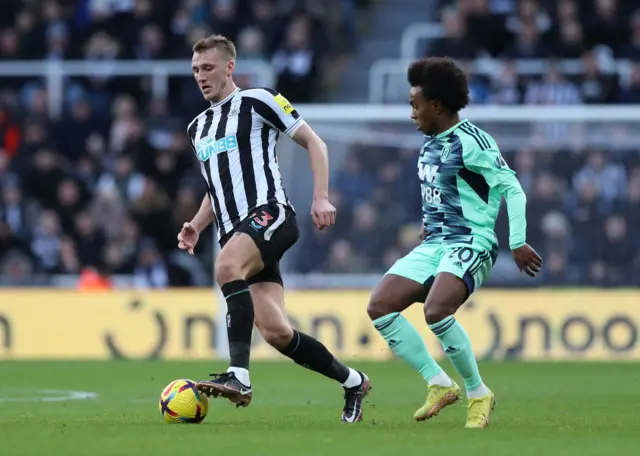 Newcastle defender Dan Burn brings the ball out from the back.