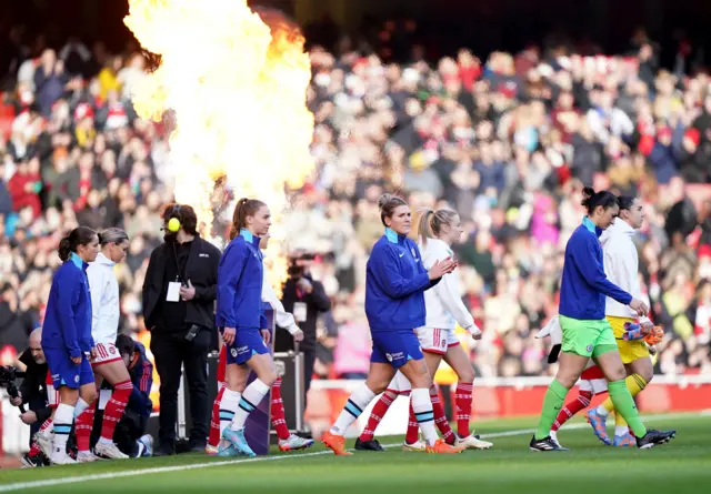 Arsenal and Chelsea players walk out onto the pitch before their derby clash.