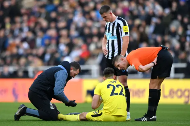 Newcastle keeper Nick Pope receives medical treatment.