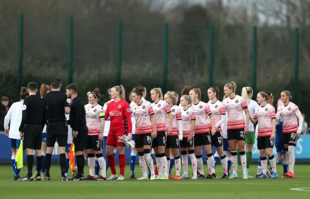 Players of both sides shake hands before the start of the game.