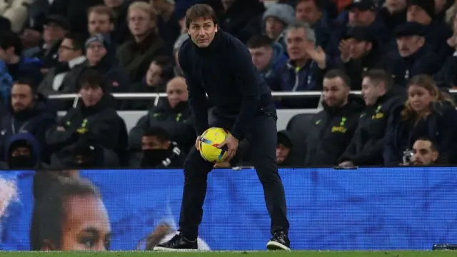 Antonio Conte clutching a football