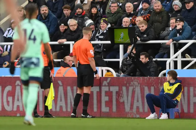 Referee Rob Jones goes to the VAR monitor.