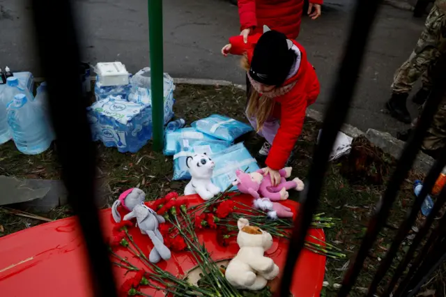 A girl leaves tributes at the site of a helicopter crash in Brovary