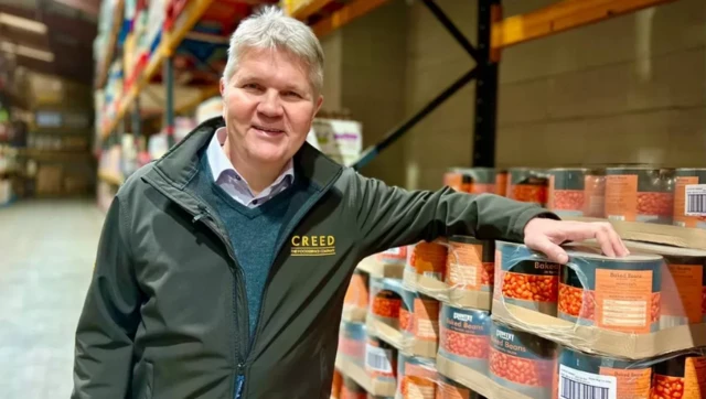 Philip de Ternant in front of a pallet of canned baked beans