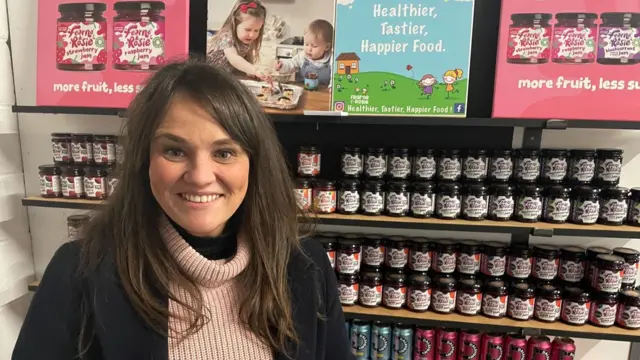 Rachel Kettlewell standing in front of jars of jam