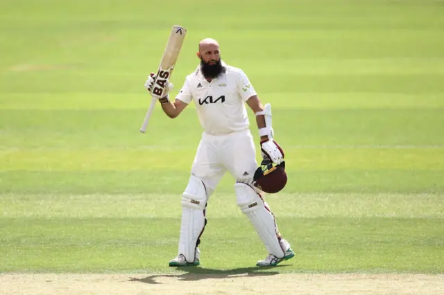 Hashim Amla of Surrey acknowledges his century during the LV= Insurance County Championship match between Surrey and Kent at The Kia Oval on June 26, 2022 in London, England