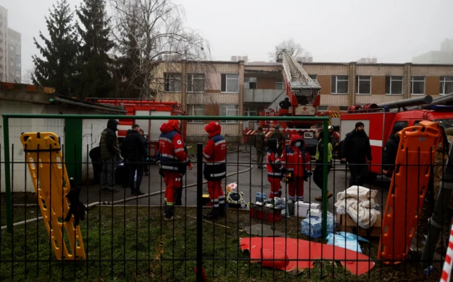 Medics and emergency personnel work at the site a where a helicopter falls on civil infrastructure buildings