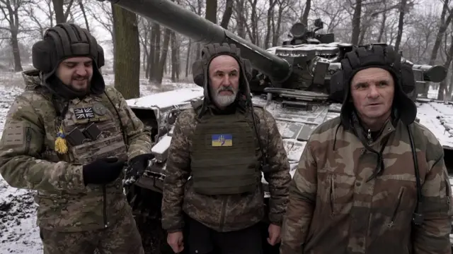 Vasyl, Volodymyr and Bogdan man a Soviet-era tank