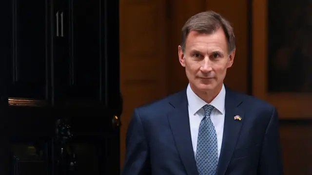 Chancellor of the Exchequer Jeremy Hunt walks out of number 11 Downing Street's front door