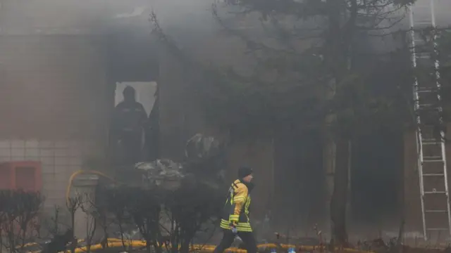 Emergency personnel work at the site of a helicopter crash