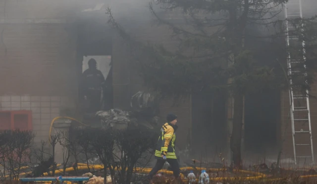 Emergency personnel work at the site of a helicopter crash, amid Russia's attack on Ukraine, in the town of Brovary