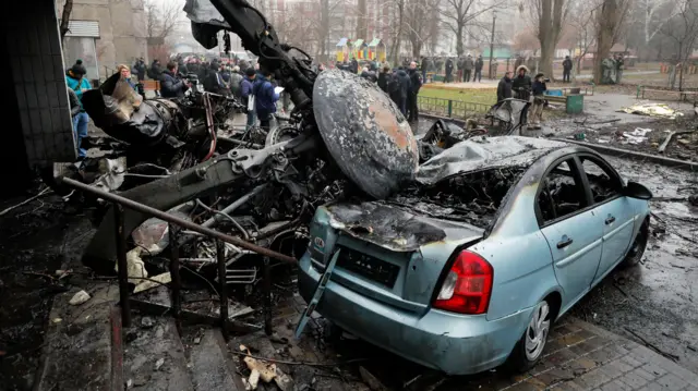 Helicopter crash debris and a crushed car in Brovary