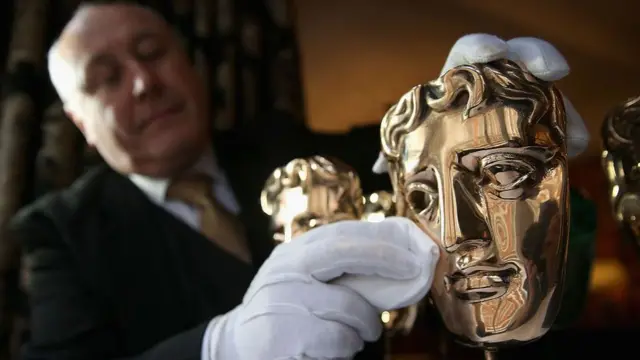 The BAFTA mask awards are polished by a butler ahead of the British Academy Film Awards