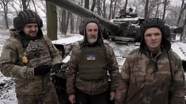 Vasyl, Volodymyr and Bogdan stand by their Soviet-era tank