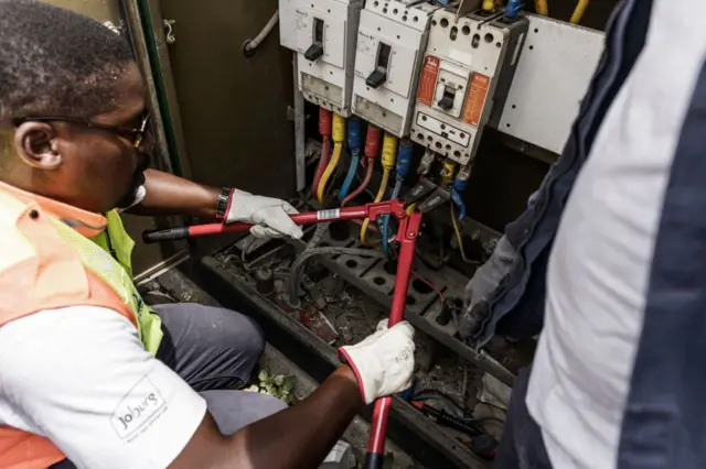 A 1city Power technician cuts the power supply at a gas station in Alexandra, Johannesburg