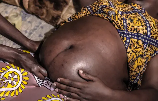 A midwife is seen massaging a pregnant lady in preparation for a safe delivery