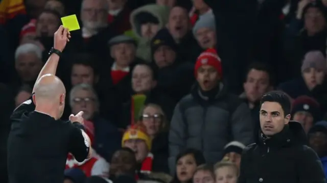 Mikel Arteta being shown a yellow card.