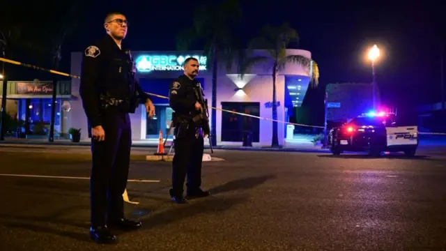 Police stand guard at the scene near the intersection of Garvey and Garfield Avenue in Monterey Park