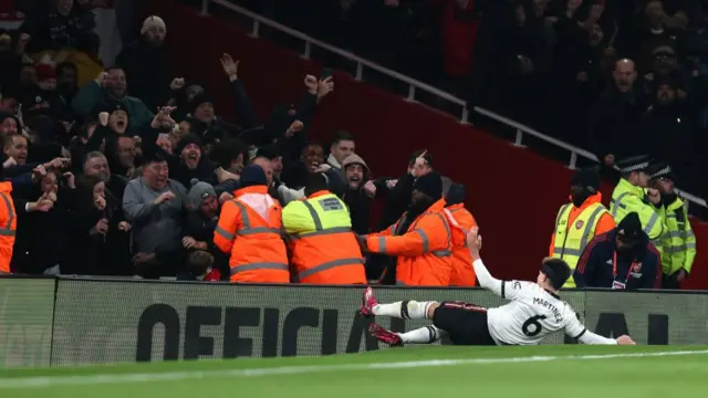 Lisandro Martinez celebrating his goal in front of United fans.