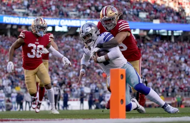 Dak Prescott is tackled by Talanoa Hufanga