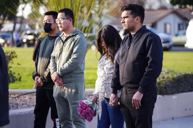 People come together in a prayer as members of the community hold a prayer vigil.