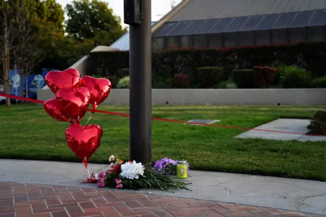 Flowers and balloons left near the scene of the shooting