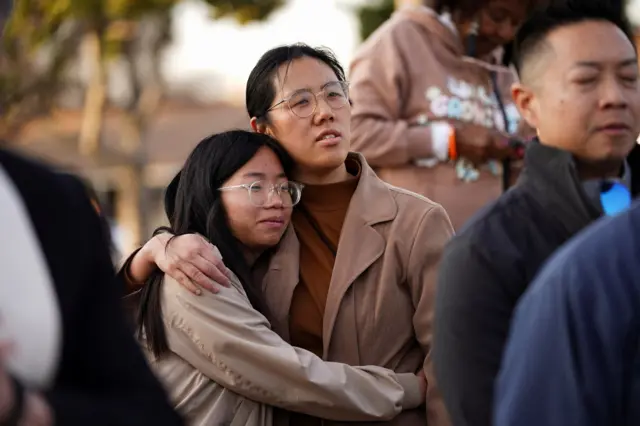 A couple holds each other as members of the community hold a prayer vigil.R