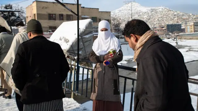 A woman in Kabul wearing a white face veil