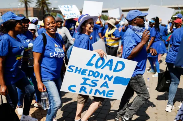 Democratic Alliance (DA) members hold placards as they march to Luthuli House, the headquarters of the