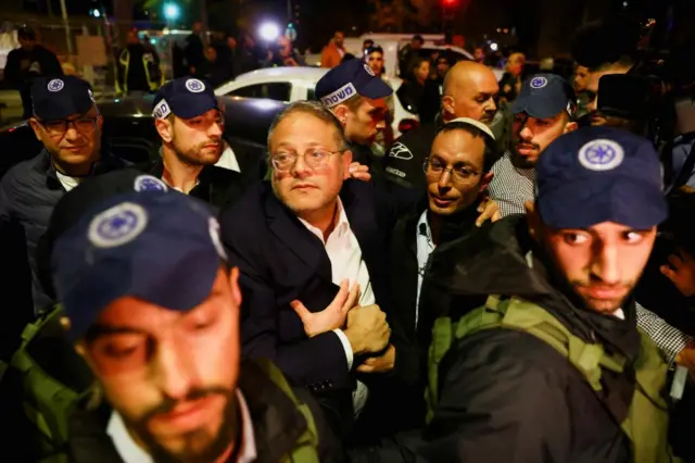 Israel's Minister of National Security Itamar Ben-Gvir stands among a group of uniformed Israeli forces