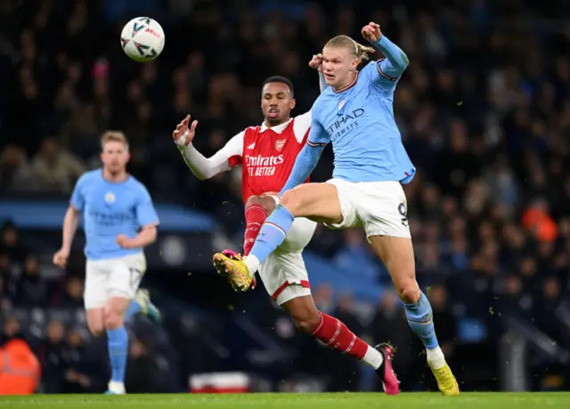 Erling Haaland gets a shot away under pressure from Gabriel Maglhaese