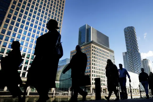 Commuters walk through Canary Wharf in London, part of the capital’s central business district.