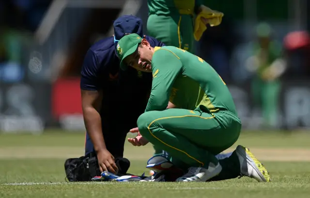 South Africa wicketkeeper Quinton de Kock receives medical treatment after a blow to the right hand