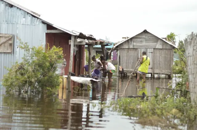 Residents of the Belle Souvenir neighbourhood by their houses submerged by water in Sambava on January 21, 2023, following the passage of Cyclone Cheneso in Madagascar - 19 January 2023.