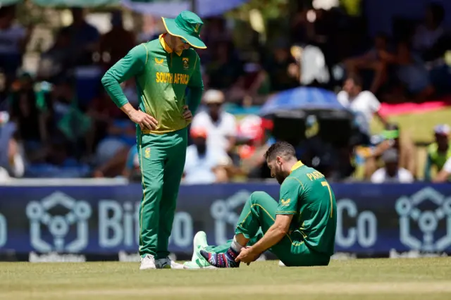 South Africa's Wayne Parnell (R) adjusts his sock during the second one day international (ODI) cricket match between South Africa and England at Mangaung Oval in Bloemfontein