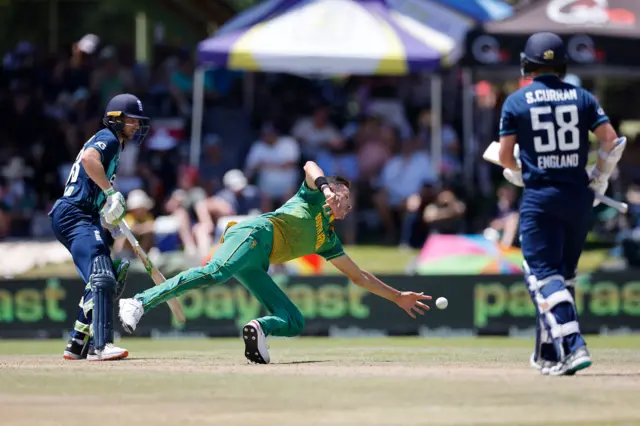 South Africa's Marco Jansen fields a ball between England's Jos Buttler (L) and England's Sam Curran (R) during the second one day international (ODI) cricket match between South Africa and England at Mangaung Oval in Bloemfontein