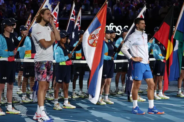 Stefanos Tsitsipas and Novak Djokovic wait for the presentation ceremony