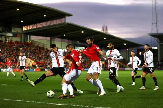 Elliot Lee of Wrexham crosses the ball past John Egan of Sheffield United