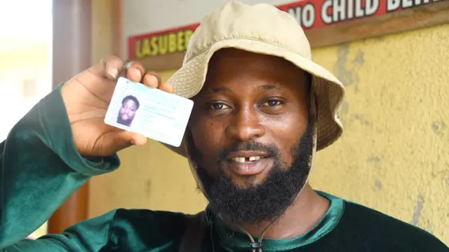 A man shows his Permanent Voters Card (PVC) after collecting it in Lagos, Nigeria - 12 January 2023