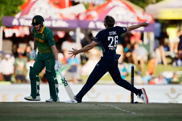 England's Olly Stone (R) delivers a ball past South Africa's David Miller (L) during the second one day international (ODI) cricket match between South Africa and England at Mangaung Oval in Bloemfontein