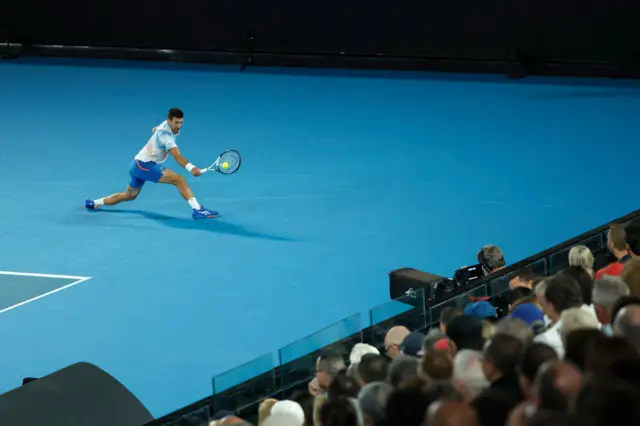 Novak Djokovic stretches to hit a backhand