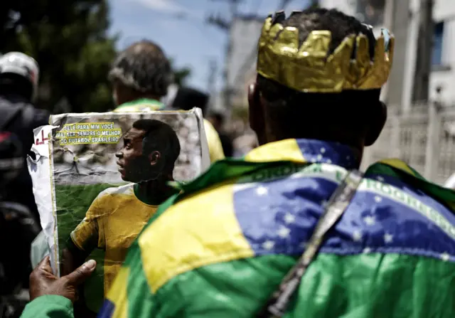 A mourner draped in a Brazil flag