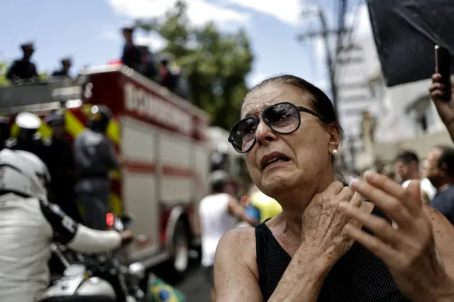 A mourner reacts as Pele's coffin passes by