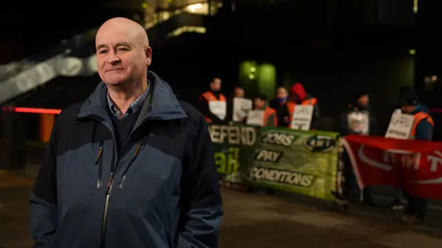 Mick Lynch, general secretary of the Rail, Maritime and Transport union (RMT), joins members on the picket line outside London Euston train station on Tuesday