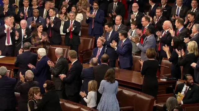 People standing around Kevin McCarthy in Congress